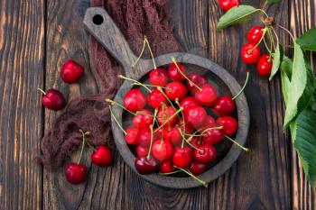 red cherry in bowl and on a table