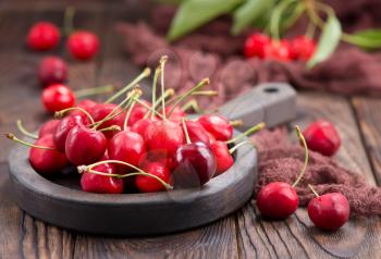 red cherry in bowl and on a table