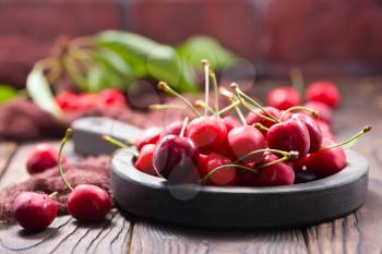 red cherry in bowl and on a table