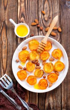 baked apricots with honey and nuts on a table