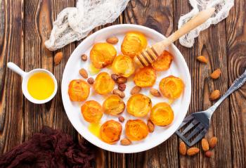 baked apricots with honey and nuts on a table