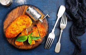 fried chicken breast on wooden board on a table