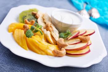 Vegan dietary food. Vitamins Summer dessert. Salad of fresh organic fruits mango banana kiwi nuts fresh mint