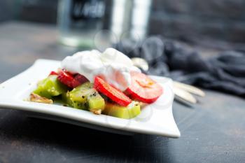 Fresh strawberry with banana kiwi and white cream. Organic food.