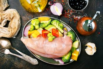 raw chicken fillet with fresh vegetables on plate