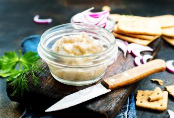 Hearty lard with garlic served with crackers on a rustic white table.