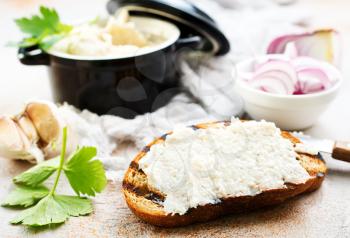 Hearty lard with garlic served with fresh bread on a rustic white table.