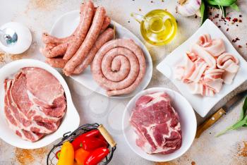 raw meat and raw sausages on the wooden board