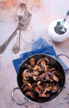 fried mushrooms on metal plate and on a table