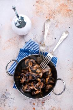 fried mushrooms on metal plate and on a table
