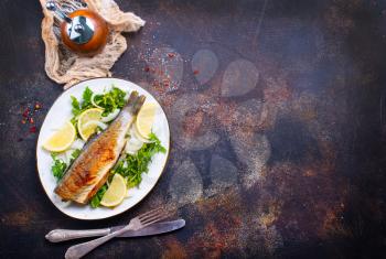 baked fish on plate and on a table