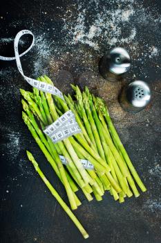 green asparagus on white plate and on a table