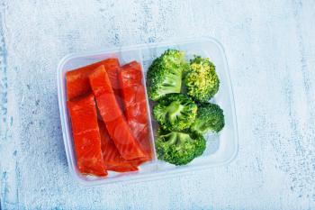 red fish with boiled broccoli, diet food in lunchbox