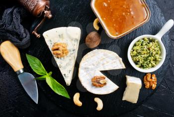 cheese with nuts and honey on wooden board