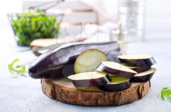 raw eggplant and knife on board, fresh eggplant