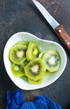 Still life image of sliced kiwi fruit on white plate