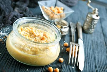 Chickpea spread or hummus with sesame seeds in glass bowl