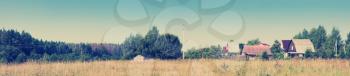 Wonderful summer panoramic view of the village and meadow. Toning effect done with a vintage retro Instagram style filter