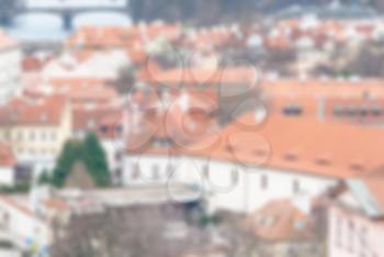Blurred defocused abstract urban texture background of red tiled roofs of houses in old city in Europe, view of vintage houses with tile roofs in old town, blurred background.