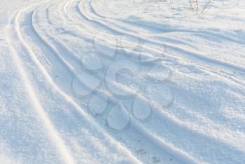 Country road on snow, car tire tracks on white winter snow field, perspective view, white winter landscape