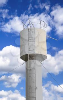 Light metal water tower on a background of the cloudy sky