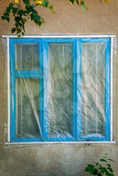Blue window of the building under the polyethylene film