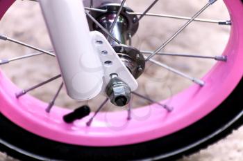 Part of the wheel of a children's pink bicycle
