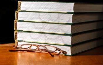 Glasses and a stack of books on the table