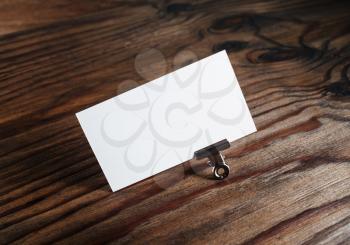 Photo of blank white business card on wooden table background. Template for branding identity.