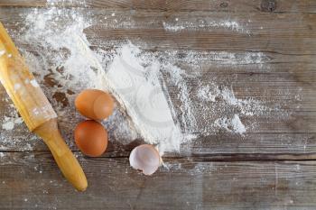 Baking background with eggs, eggshells, flour and rolling pin.