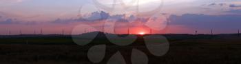 Sunset on the background of the rural landscape. Panoramic shot.