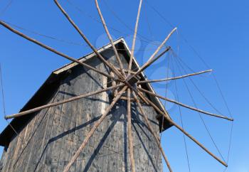 Old wooden windmill in the background of the blue sky