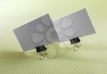 Photo of two blank business cards on a green background.