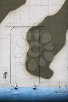 Military painted matte metal background texture with rivets. Door of an old airplane. Vertical shot.