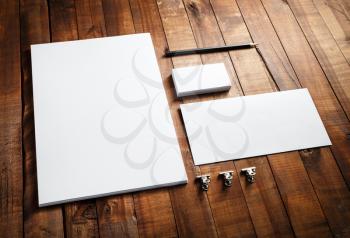 Blank stationery and corporate identity set on vintage wooden table background: letterhead, business cards, envelope and pencil. Blank mock-up for design portfolios.