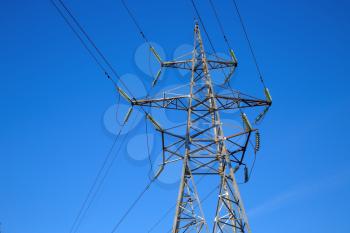 Electricity pylon on blue sky background. High voltage tower.