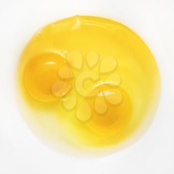 Raw eggs on white plate. Two broken eggs. Yolk and white.