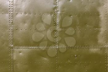 Abstract military green metal plates background texture with seams and rivets.