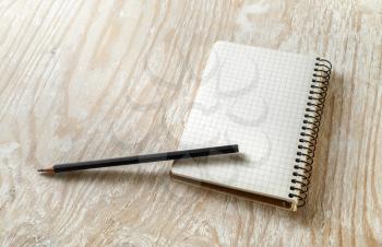 Photo of blank sketchbook with a pencil on light wooden background with soft shadows. Template for graphic designers portfolios.