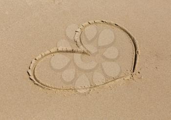 Heart drawn in the sand. Shallow depth of field.