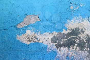 Blue painted grunge concrete wall. Weathered peeling paint texture. Blue weathered background. Bright blue paint texture, cracked over time.