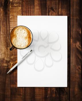 Blank paperwork mock-up. Blank letterhead with plenty of copy space, coffee cup and pen. Blank template for branding identity on vintage wooden table background. Top view.