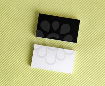 Blank black and white business cards on a green background. Template for ID. Top view.