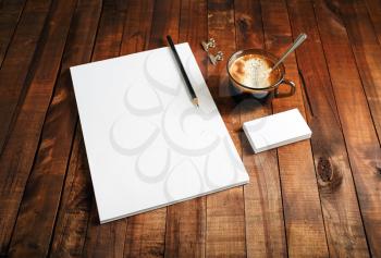 Paper, letterhead, coffee cup and pencil on wooden table background. Mock-up for branding identity. Blank template for design portfolios. Top view.