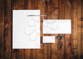 Blank stationery set on vintage wood background. Letterhead, business card, envelope and pen. Blank template for branding identity. Top view.
