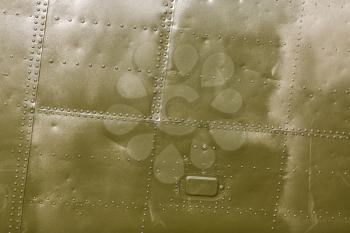 Abstract painted khaki metal background with rivets. Riveted  military green texture.