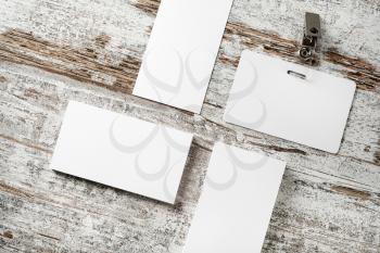 Photo of blank business cards and badge on vintage wooden table background. Blank template for placing your design.