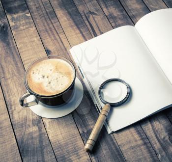 Blank book, magnifie and coffee cup on vintage wood table background. Responsive design template.