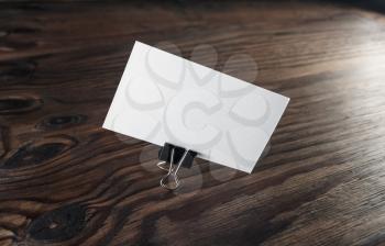 Blank business card with clip on wooden background. Template for ID. Identity design.