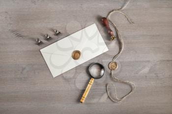 Vintage letter envelope with golden wax seal, stamp and magnifier, at wood table background. Mock-up for your design. Flat lay.